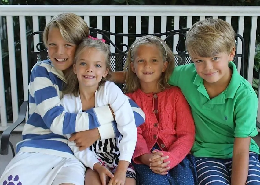 Mike holding his younger sister, Clara while sitting on a bench with Jackson and Clemmie in August 2014