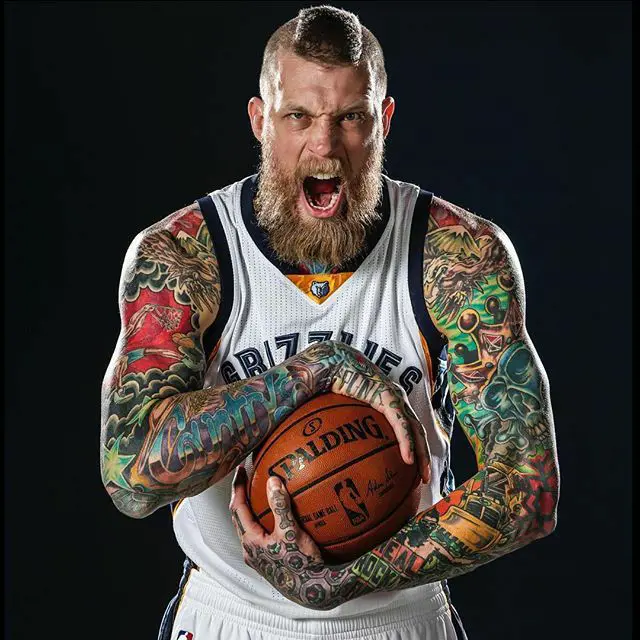 Andersen's biceps and body is covered in colorful tattoos