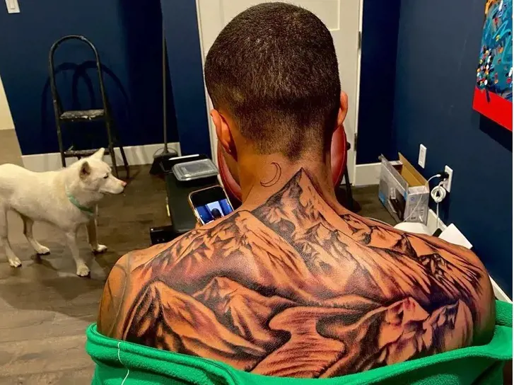 Kuzman inked mountain range on his back to pay homage to his alma mater
