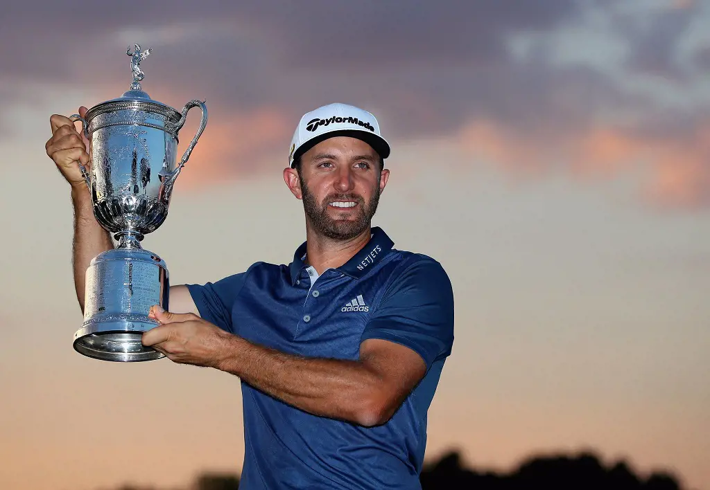 Dustin Johnson lifting his 2016 U.S. Open Cup in 2016, wearing Adidas gear as a endorser.