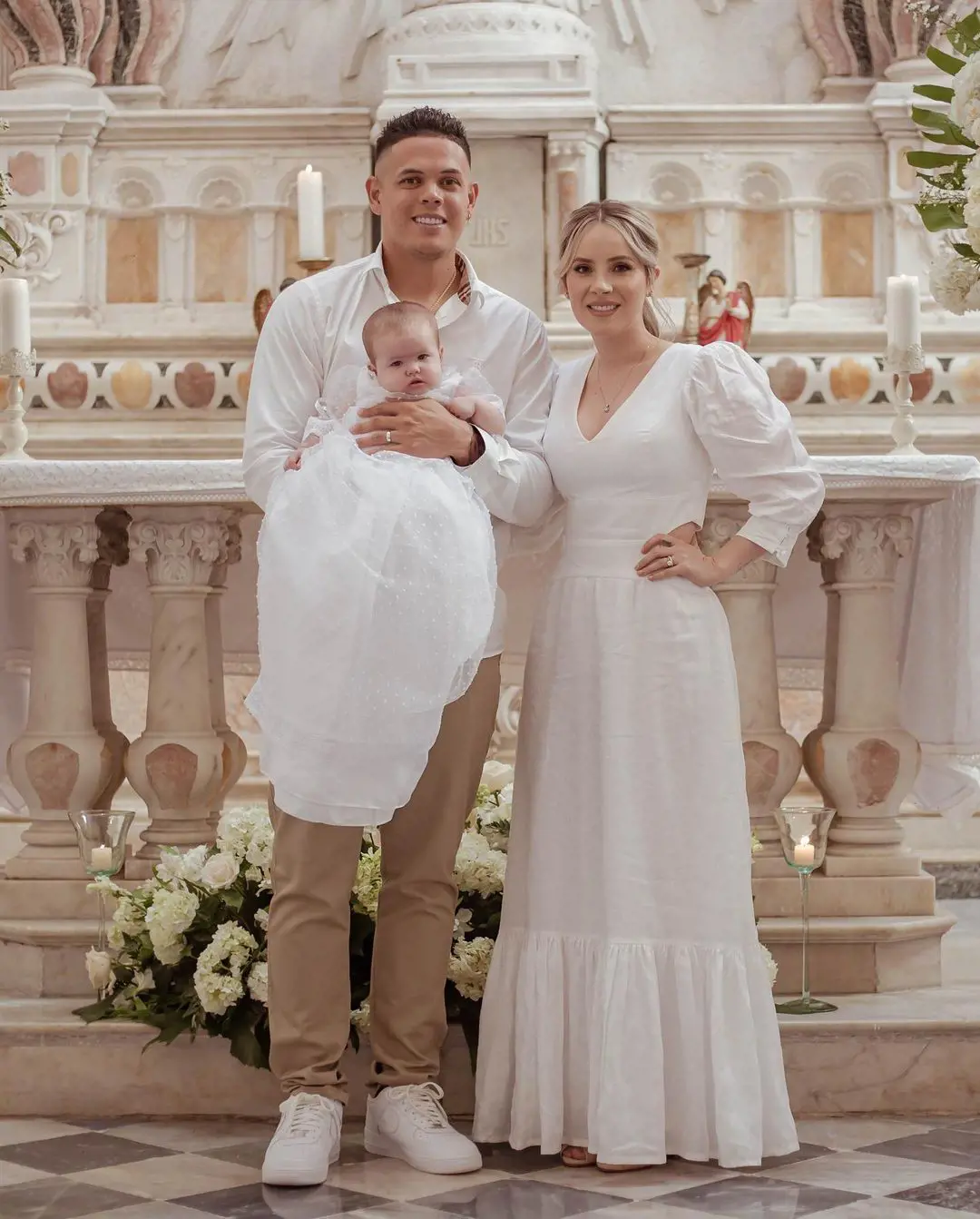 Gio and Danna holding their daughter during her baptism