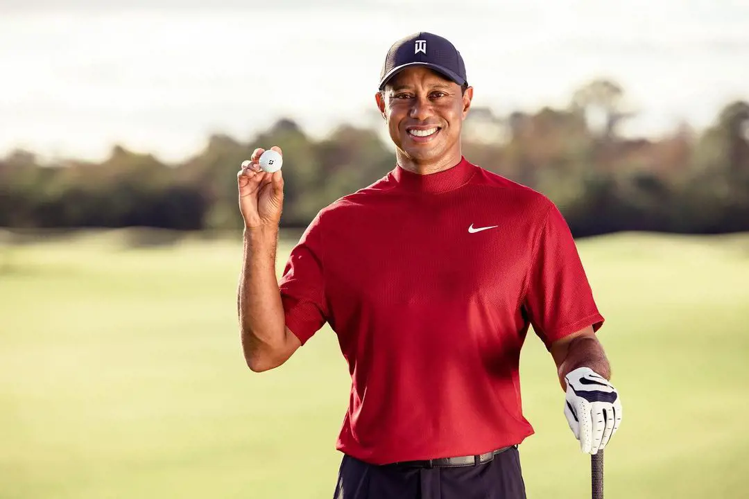 Tiger Woods sporting a red Nike brand t-shirt while promoting PopStroke's golf ball