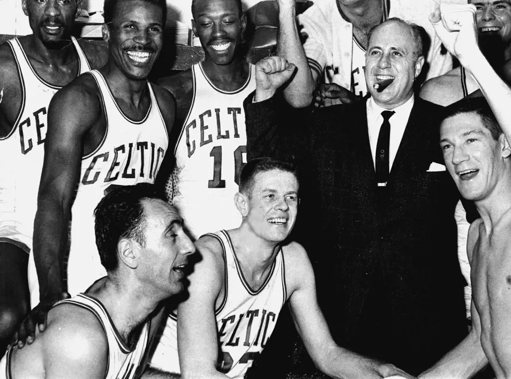 The Celtics celebrated with Coach Red Auerbach after defeating the Cincinnati Royals, 142-131