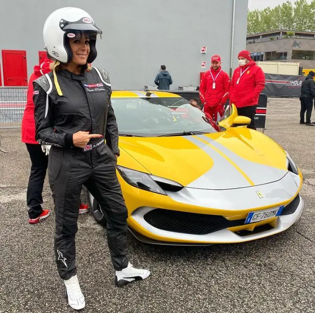Natalie posing in front of Ferrari 296 at Autodromo Enzo e Dino Ferrari di Imola on 21 April 2022.